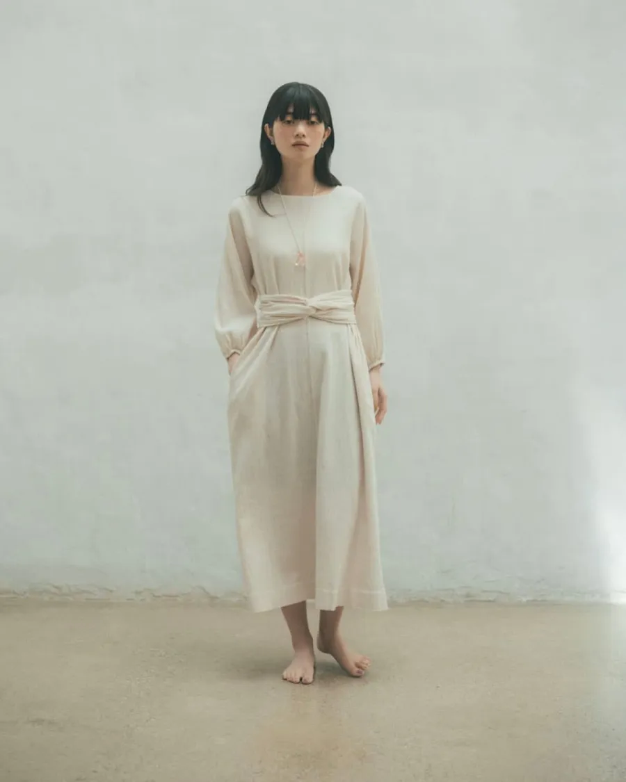 BIWACOTTONのベージュワンピースにGleicheniaのCAIRNペンダントを合わせた全身スタイリング