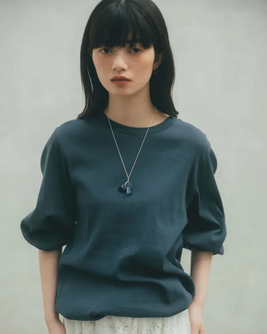 ネイビーのBIWACOTTONトップスにGleicheniaのブルーガラスペンダントを着用したスタイリング