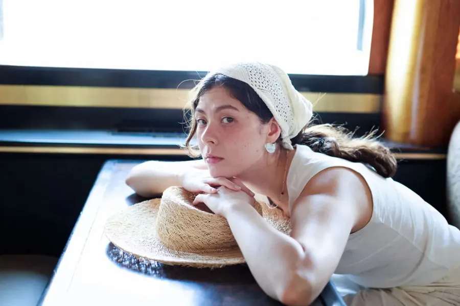 エモン久瑠美さんがビワコットンの装いにGleichenia CAIRNコレクションを合わせて着用している様子