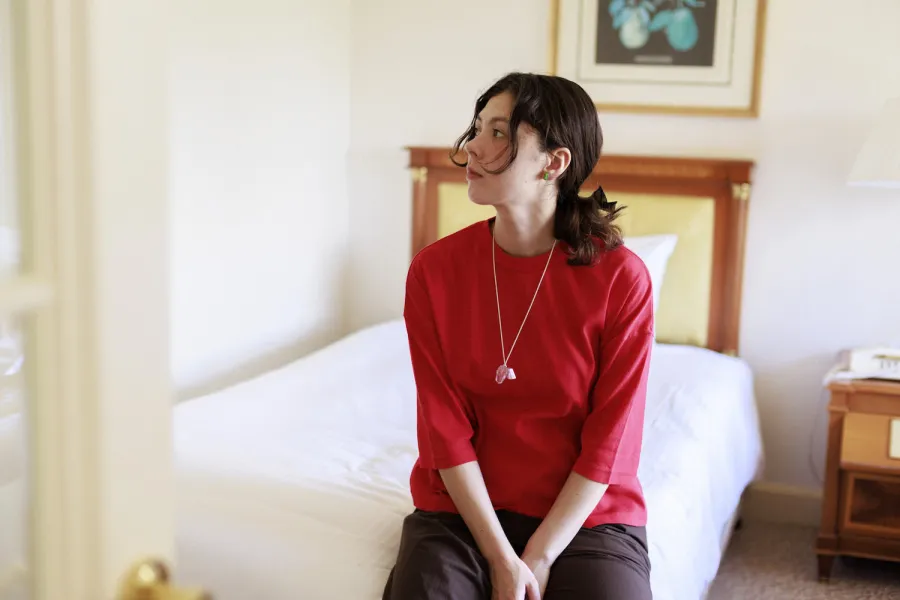 エモン久瑠美さんがビワコットンの装いにGleichenia CAIRNコレクションを合わせて着用している様子